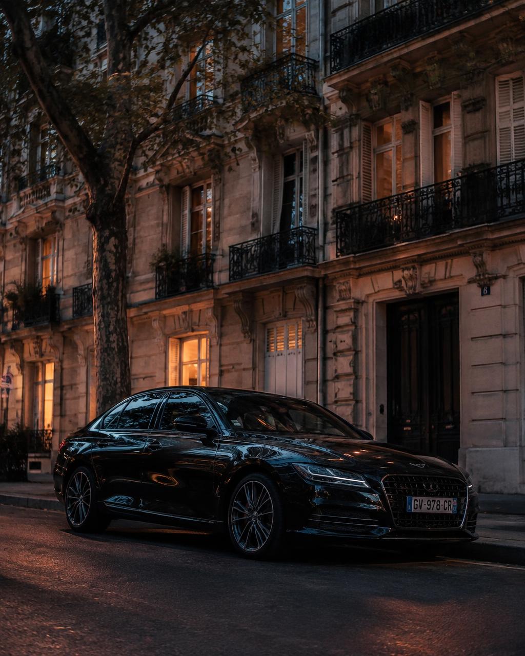 Berline noire garée devant un immeuble parisien au crépuscule